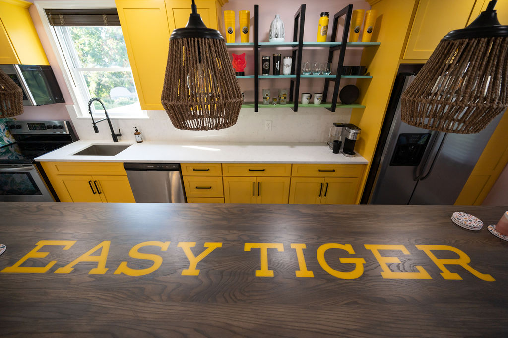 custom island white counters and yellow cabinets with custom shelving